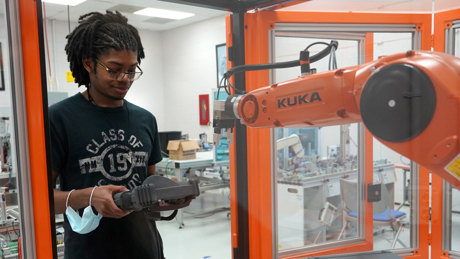 student controlling robot in lab