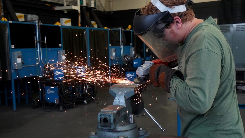 student welding with sparks flying